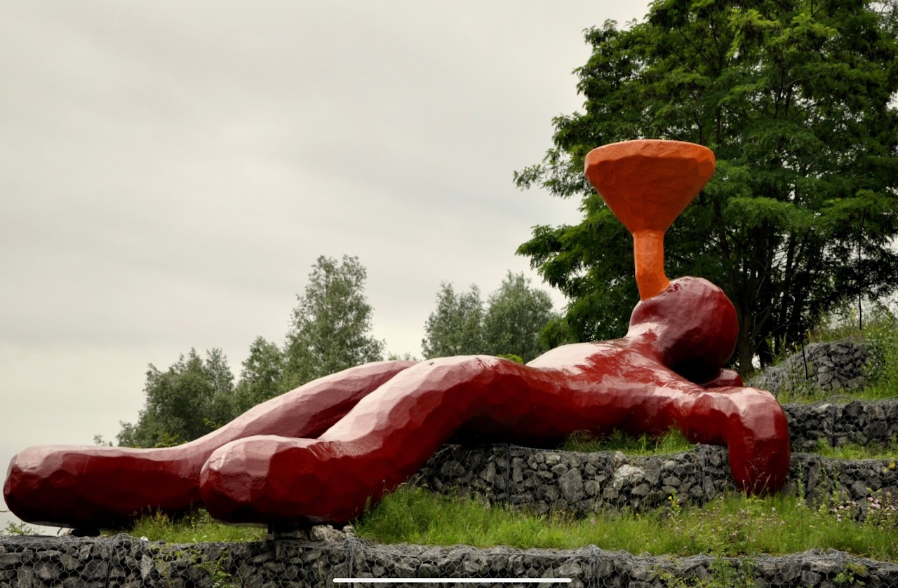 Rood beeld van een liggende persoon met een oranje trechter boven het gezicht, op een groene helling.
